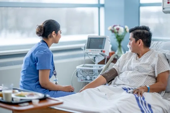 Nurse checking a patient's vitals in a hospital bed